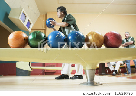 Side view of man with bowling balls 11629789