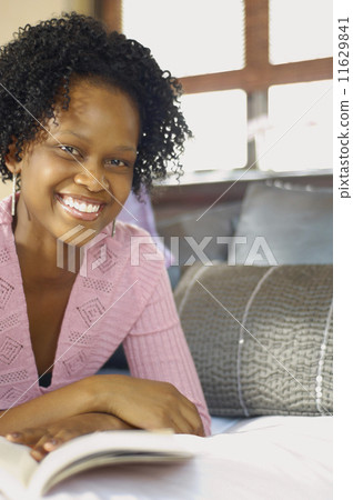 Young African woman reading on bed Young African woman reading on bed 11629841