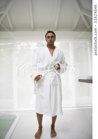 Man tying bathrobe in bathroom 11629846