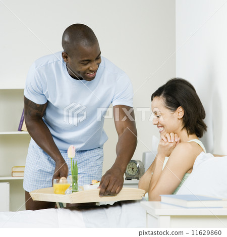 African man serving girlfriend breakfast in bed African man serving girlfriend breakfast in bed 11629860