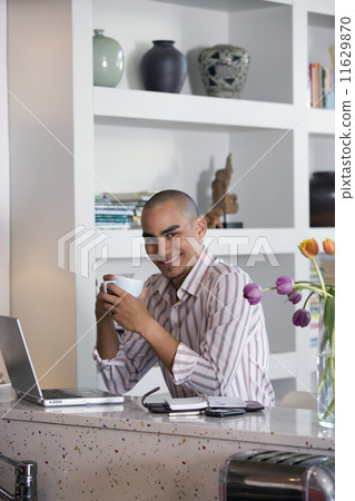 African American man holding coffee mug 11629870
