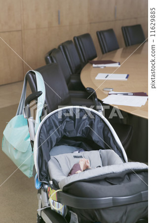 Baby in stroller next to conference table 11629885