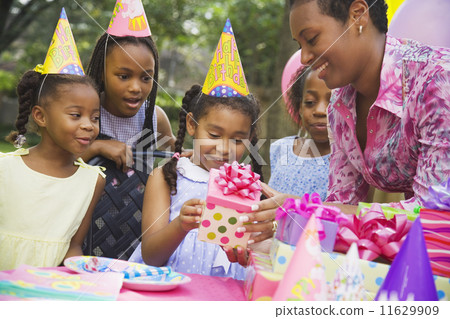 African girl receiving gift at birthday party African girl receiving gift at birthday party 11629909