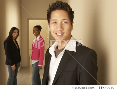 Businesspeople smiling in hallway 11629949