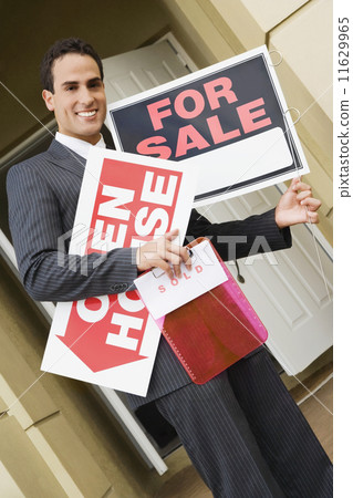 Hispanic real estate agent holding signs Hispanic real estate agent holding signs 11629965