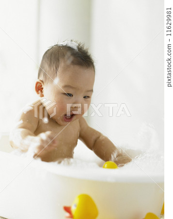 Baby boy playing in the bathtub 11629981