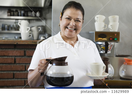 Hispanic waitress holding coffee pot and mug Hispanic waitress holding coffee pot and mug 11629989
