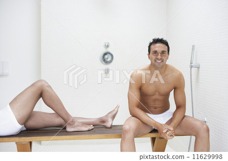 Two men in underwear on bench in bathroom 11629998