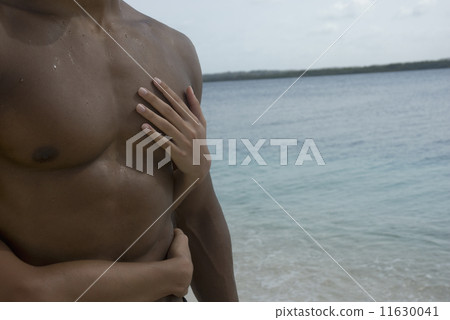 Hispanic couple hugging at beach 11630041
