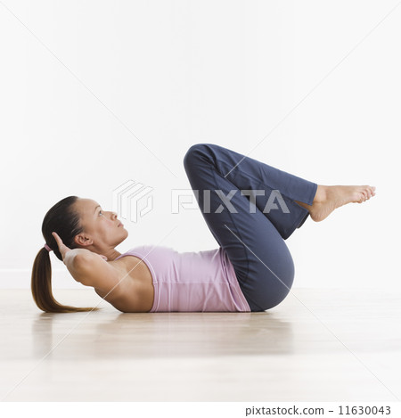 Side view of woman doing crunches Side view of woman doing crunches 11630043