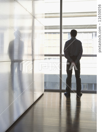 Businessman looking out the window 11630056