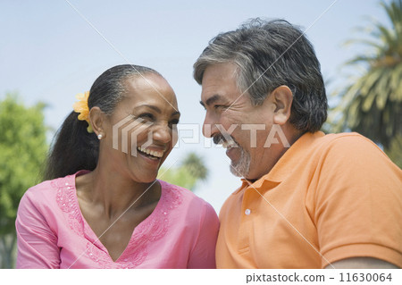 Multi-ethnic couple smiling at each other Multi-ethnic couple smiling at each other 11630064