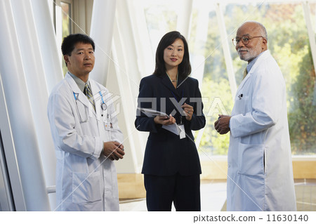 Two male doctors talking to Asian businesswoman  11630140