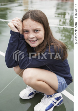 Girl crouching on playground 11630153