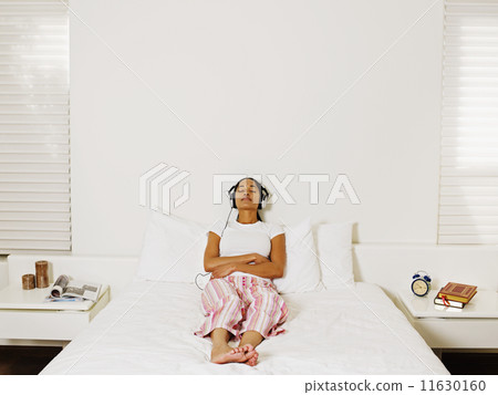 African woman listening to headphones African woman listening to headphones 11630160