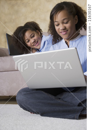 African twin sisters looking at laptop 11630167