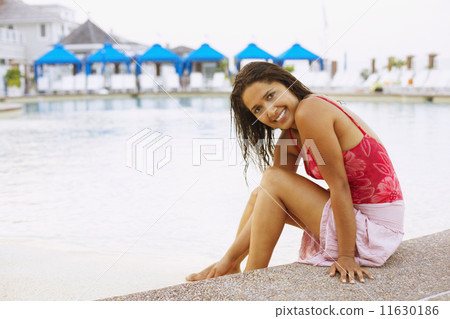 Hispanic woman sitting next to swimming pool 11630186