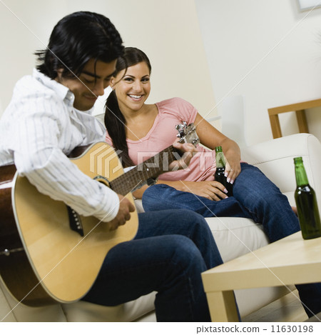 Asian man playing guitar for girlfriend 11630198