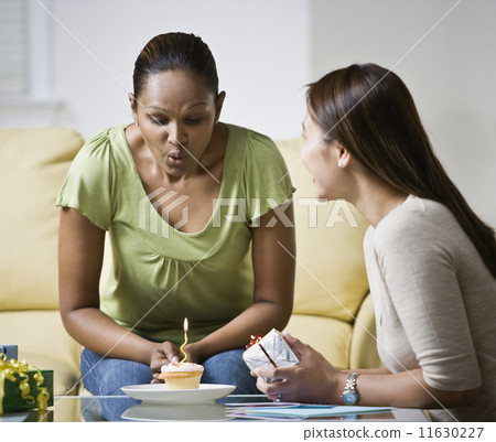 Indian woman blowing out birthday candle Indian woman blowing out birthday candle 11630227