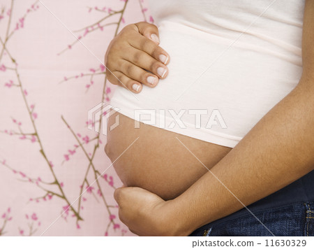 Pregnant African American woman with hands on belly Pregnant African American woman with hands on belly 11630329