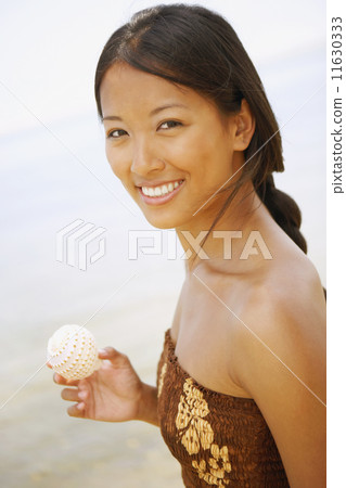 Asian woman holding seashell 11630333