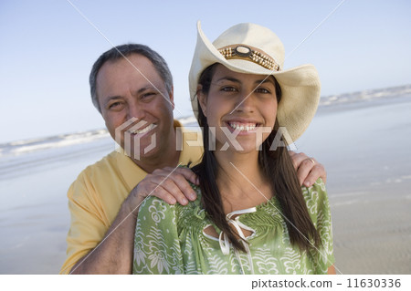 Hispanic father with hands on daughter's shoulders 11630336