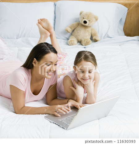Hispanic sisters looking at laptop Hispanic sisters looking at laptop 11630393