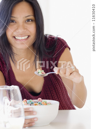 Pacific Islander woman eating cereal Pacific Islander woman eating cereal 11630410