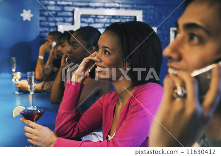 Group of people talking on cell phones at bar 11630412