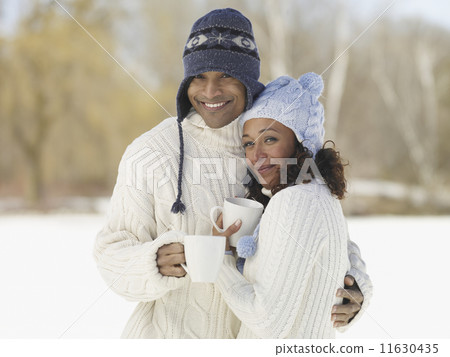 African couple hugging in hats and sweaters 11630435