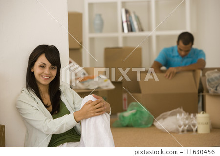 Young couple unpacking boxes in new house Young couple unpacking boxes in new house 11630456