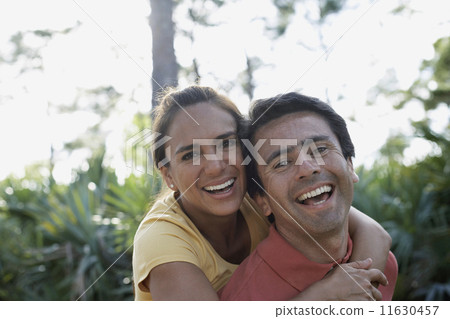Hispanic man giving girlfriend piggy back ride Hispanic man giving girlfriend piggy back ride 11630457