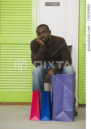 African man waiting outside dressing rooms 11630460