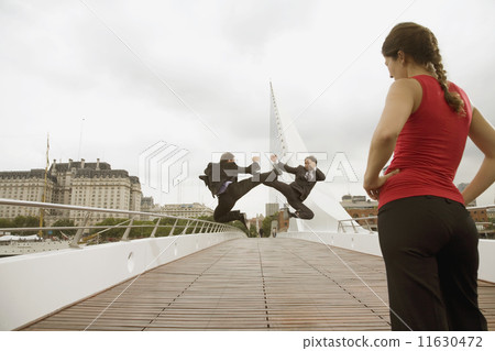 Multi-ethnic businessmen fighting next to woman 11630472