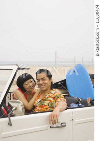 Asian couple sitting convertible Asian couple sitting convertible 11630474