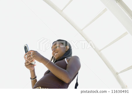 Low angle view of Indian woman dialing cell phone 11630491