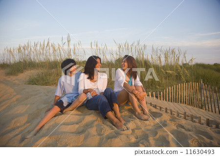 Asian woman and children sitting on beach 11630493