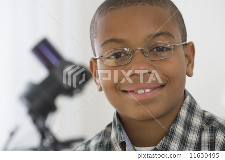 Close up of African boy with microscope in background Close up of African boy with microscope in background 11630495
