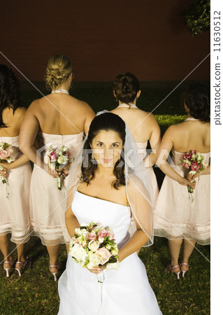 Hispanic bride in front of bridesmaids 11630512