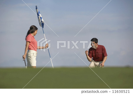 Hispanic couple playing golf Hispanic couple playing golf 11630521