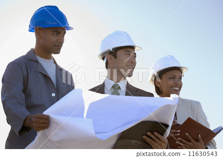 Multi-ethnic businesspeople and construction worker with blueprints 11630543
