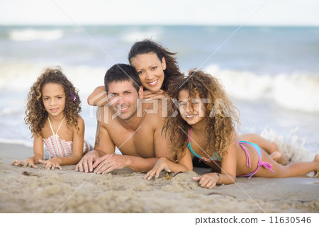 Hispanic family laying on beach 11630546