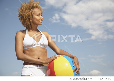 African woman holding beach ball 11630549