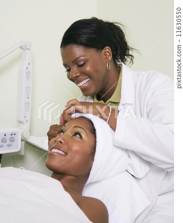 African woman receiving spa facial treatment 11630550