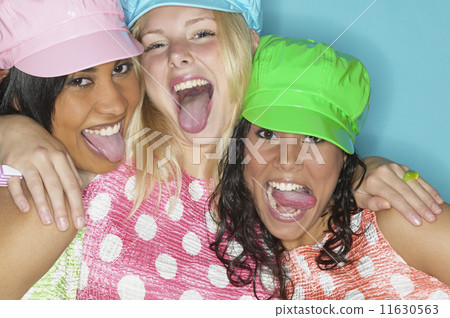 Three young women laughing and sticking their tongues out 11630563