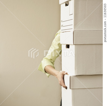 Businesswoman carrying stack of boxes 11630583