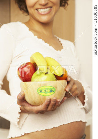 Pregnant Mixed Race woman holding bowl of fruit Pregnant Mixed Race woman holding bowl of fruit 11630585