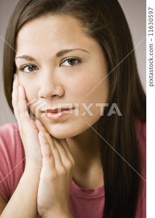 Asian girl resting chin on hands Asian girl resting chin on hands 11630597