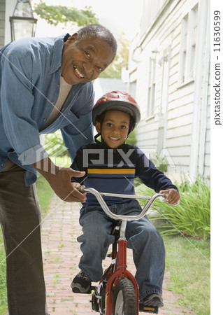 African grandfather teaching grandson to ride bicycle African grandfather teaching grandson to ride bicycle 11630599