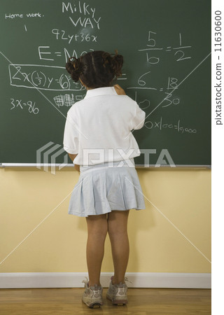 Young girl writing on blackboard Young girl writing on blackboard 11630600
